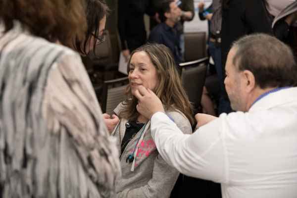 Physician instructor reviewing facial procedure on patient