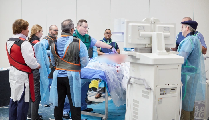 Pain Management physicians stand around cadaver specimen with instructor